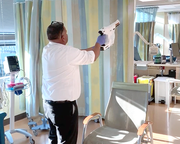 Man spraying hospital room for infection prevention